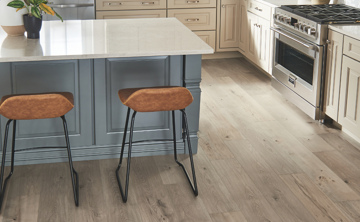 Laminate flooring in a kitchen with custom cabinets and two barstools